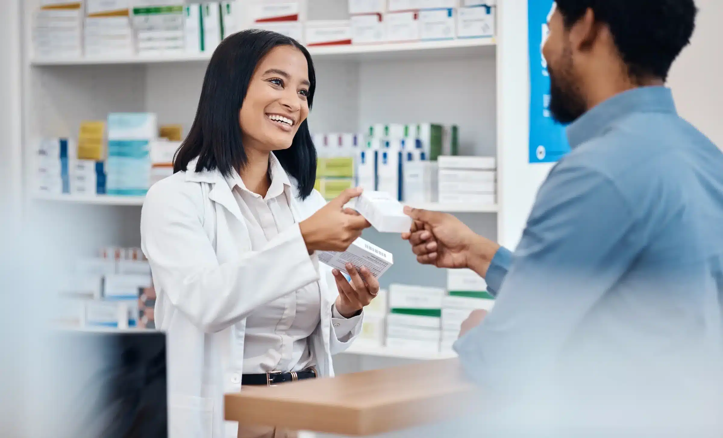 Imagem ilustrativa de uma farmacêutica atendendo cliente em farmácia localizada dentro de supermercado, conforme exigência da nova legislação.