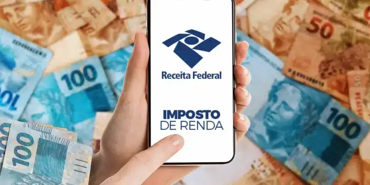 Pessoa usa celular com aplicativo da Receita Federal sobre notas de real espalhadas