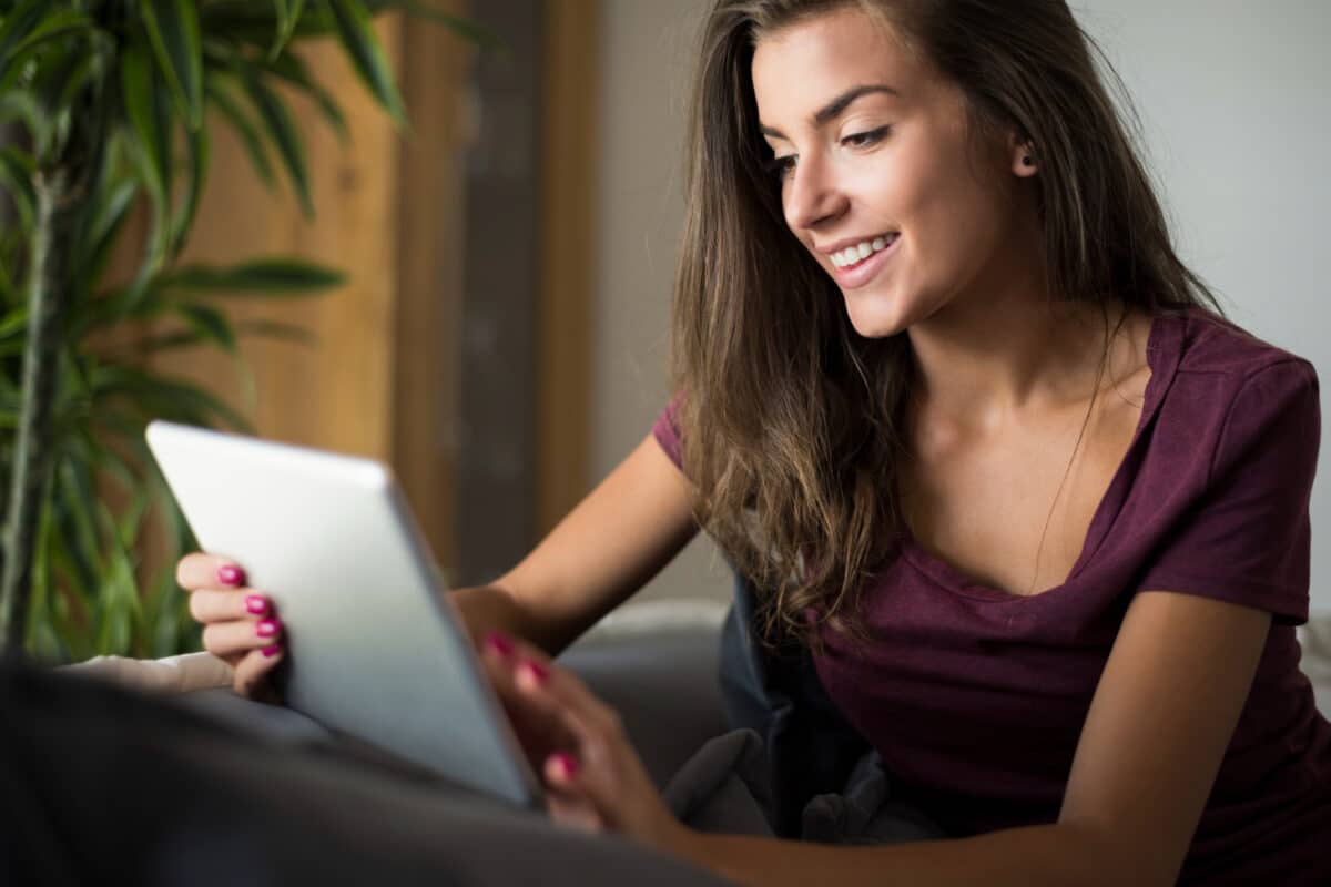 Jovem sorrindo ao usar tablet, representando candidato às vagas de Jovem Aprendiz da Shopee 2026