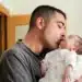 Pai beijando seu recém-nascido em momento de carinho, simbolizando o impacto da ampliação da licença-paternidade.