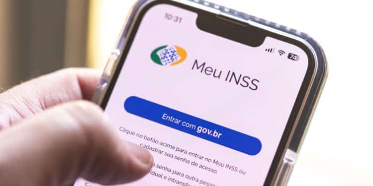 Mão segura celular exibindo tela do aplicativo Meu INSS com botão Entrar com gov.br em destaque