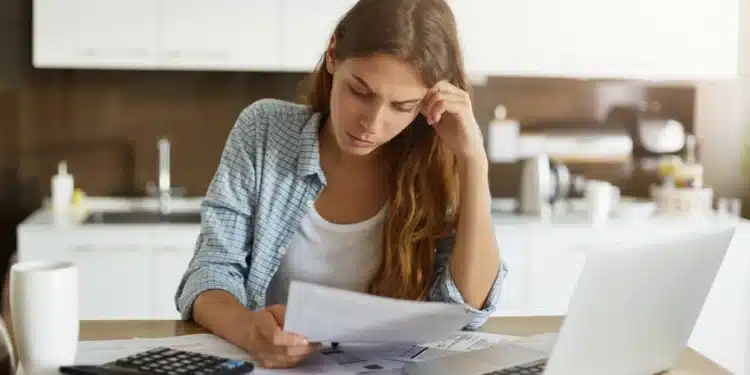 Pessoa analisando contas e faturas enquanto busca opções para renegociar dívidas bancárias em mutirão nacional.