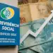 Placa do INSS Previdência Social com seta de crescimento e notas de reais ao fundo — pagamento INSS abril 2026