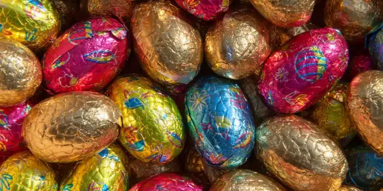 Ovos de Páscoa coloridos embalados em papel metalizado representando a chegada da Páscoa 2026 no calendário.