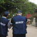Dois agentes do IBGE uniformizados de costas caminhando em área urbana — concurso IBGE recenseador 27 mil vagas 2026