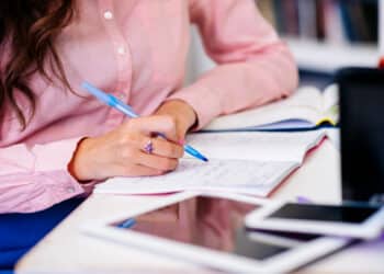 Candidata estudando e anotando em caderno para o processo seletivo da Prefeitura de Chapadão do Céu GO com salários de até R$ 3.156 para Agente de Saúde