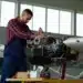 Técnico aeronáutico ajustando motor de avião, profissão técnica com altos salários.