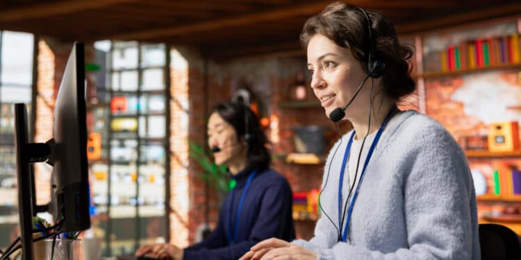 Duas atendentes de call center com headset em frente ao computador — profissões impactadas pela automação e inteligência artificial com risco elevado de desaparecer até 2035