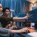 Profissionais analisando dados em computadores enquanto utilizam ferramentas de inteligência artificial para programação, marketing e análise financeira.