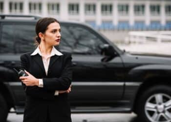 Profissional de segurança privada monitorando área externa enquanto protege veículo de transporte de valores.