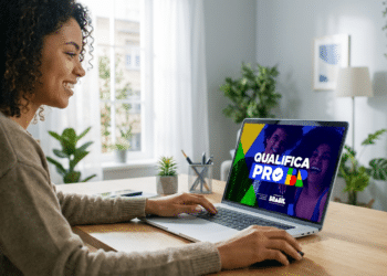 Mulher sorrindo utiliza notebook com tela exibindo plataforma Qualifica Pro