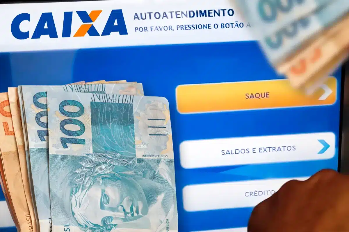 Mão segurando cédulas de 50 e 100 reais diante de tela de autoatendimento bancário
