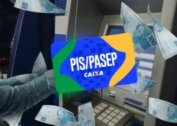 Caixa eletrônico com cartão PIS Pasep da Caixa e cédulas de reais ao redor