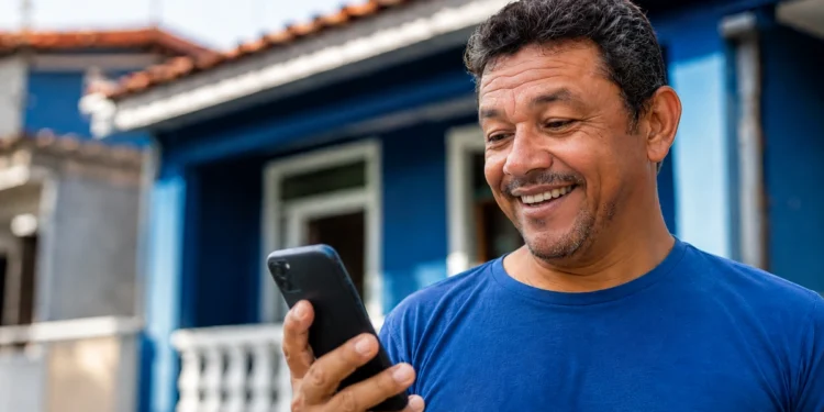 Homem consulta o celular para solicitar o Saque Calamidade de até R$ 6.220 pelo aplicativo do FGTS