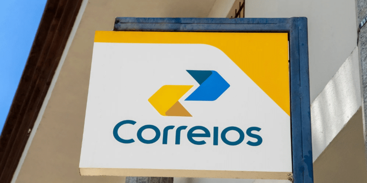 Placa dos Correios com logotipo amarelo e azul fixada na fachada de prédio