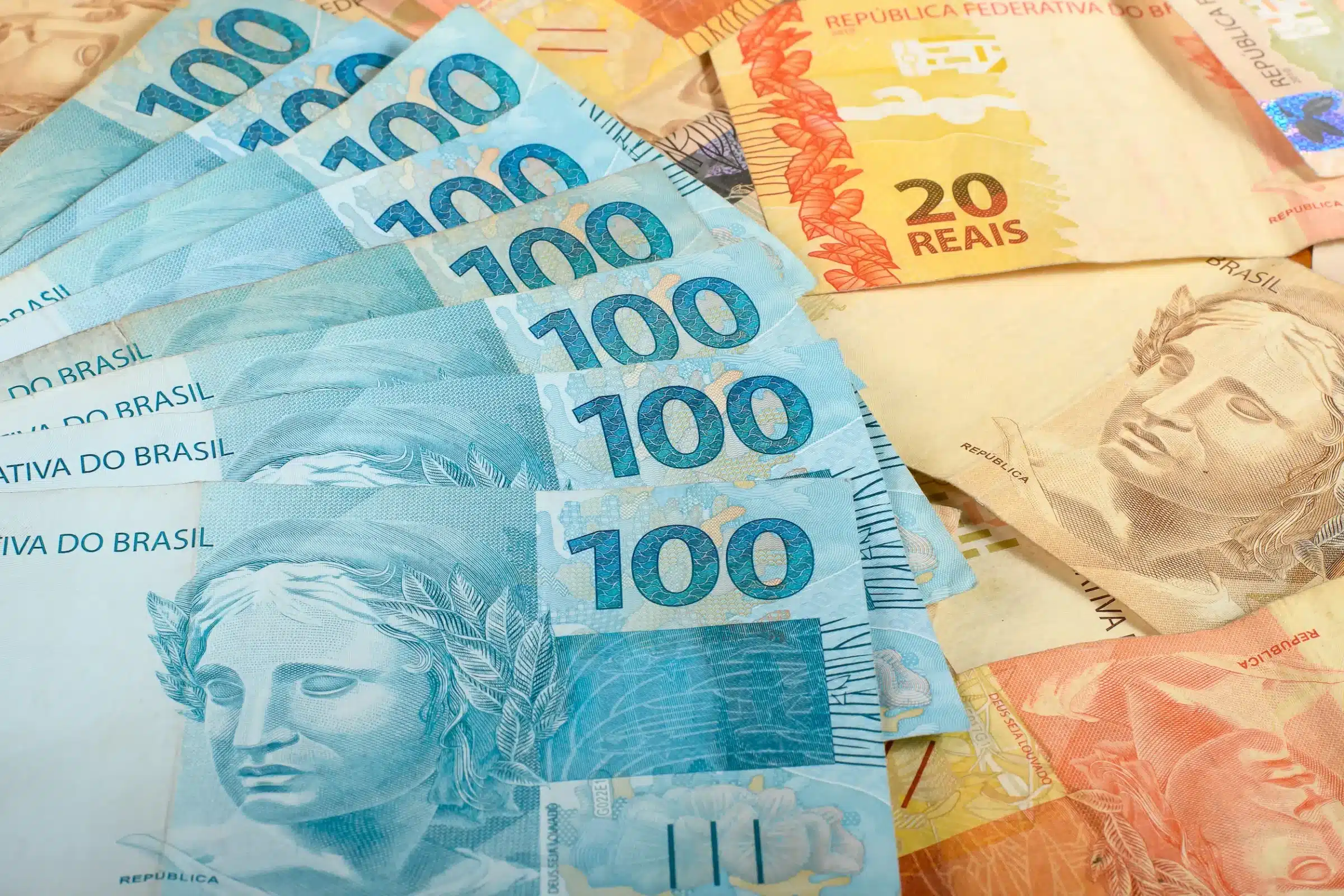Notas de 100 reais e 20 reais do Brasil, representando o valor do 13º salário do INSS em 2026.