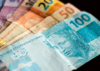 Notas de dinheiro em formato de 13º salário do INSS, destacando valores de R$ 20, R$ 50 e R$ 100, para ilustrar o pagamento da primeira parcela do 13º salário de 2026.