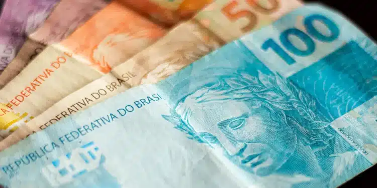 Notas de dinheiro em formato de 13º salário do INSS, destacando valores de R$ 20, R$ 50 e R$ 100, para ilustrar o pagamento da primeira parcela do 13º salário de 2026.