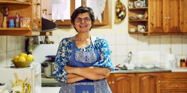 Dona de casa na cozinha representando mulheres que precisam contribuir ao INSS para garantir aposentadoria em 2026.