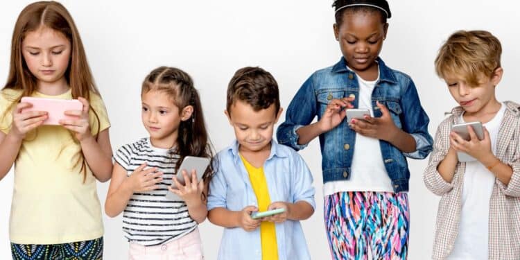 Crianças utilizando smartphones em contexto de uso intenso de redes sociais e tecnologia digital.