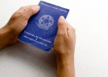 Mãos segurando uma carteira de trabalho.
