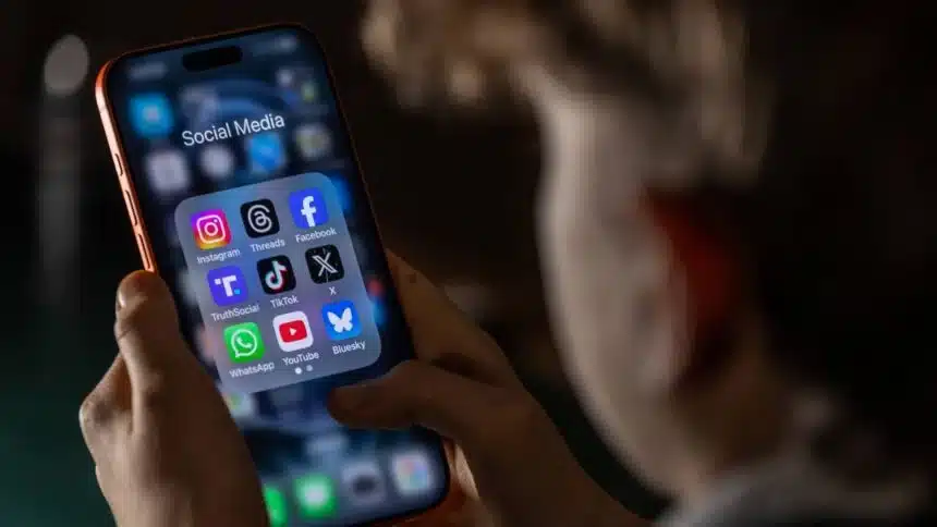 Adolescente usando smartphone com aplicativos de redes sociais após mudanças de classificação indicativa do ECA Digital.