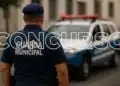Guarda municipal de costas em frente a viatura policial durante operação urbana.