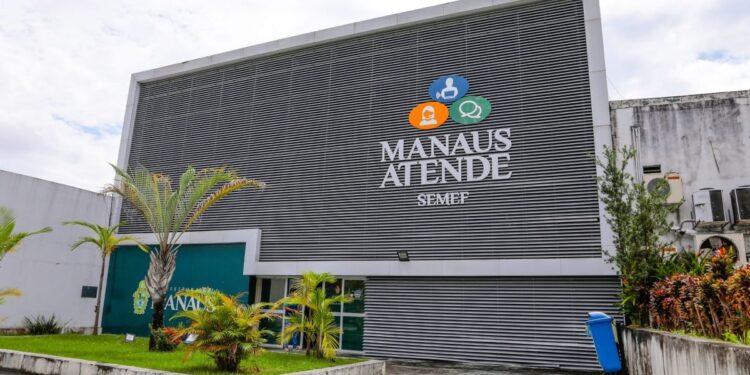Fachada do prédio da SEMEF Manaus Atende, com estrutura cinza moderna e logomarca colorida, representando a sede da Secretaria Municipal de Finanças de Manaus.