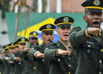 Militares do Exército Brasileiro em formação durante cerimônia oficial sob chuva.
