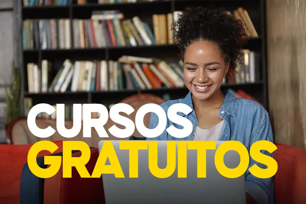 Jovem sorrindo e mexendo em notebook cinza.