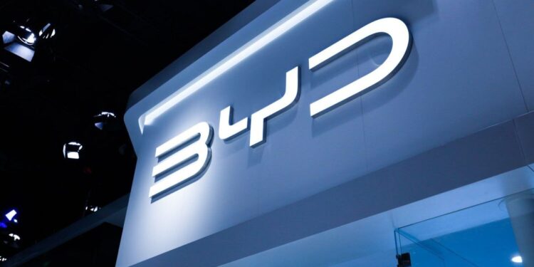 Fachada iluminada de loja BYD com logotipo em destaque.