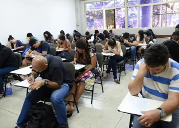 Alunos concentrados durante prova do Encceja, destacando a importância de prestar atenção aos detalhes do exame.
