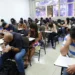 Alunos concentrados durante prova do Encceja, destacando a importância de prestar atenção aos detalhes do exame.