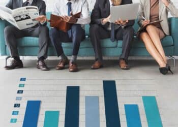 Profissionais em ambiente corporativo com gráfico ilustrando debate sobre escalas de trabalho e possível fim da jornada 6x1 no Brasil.