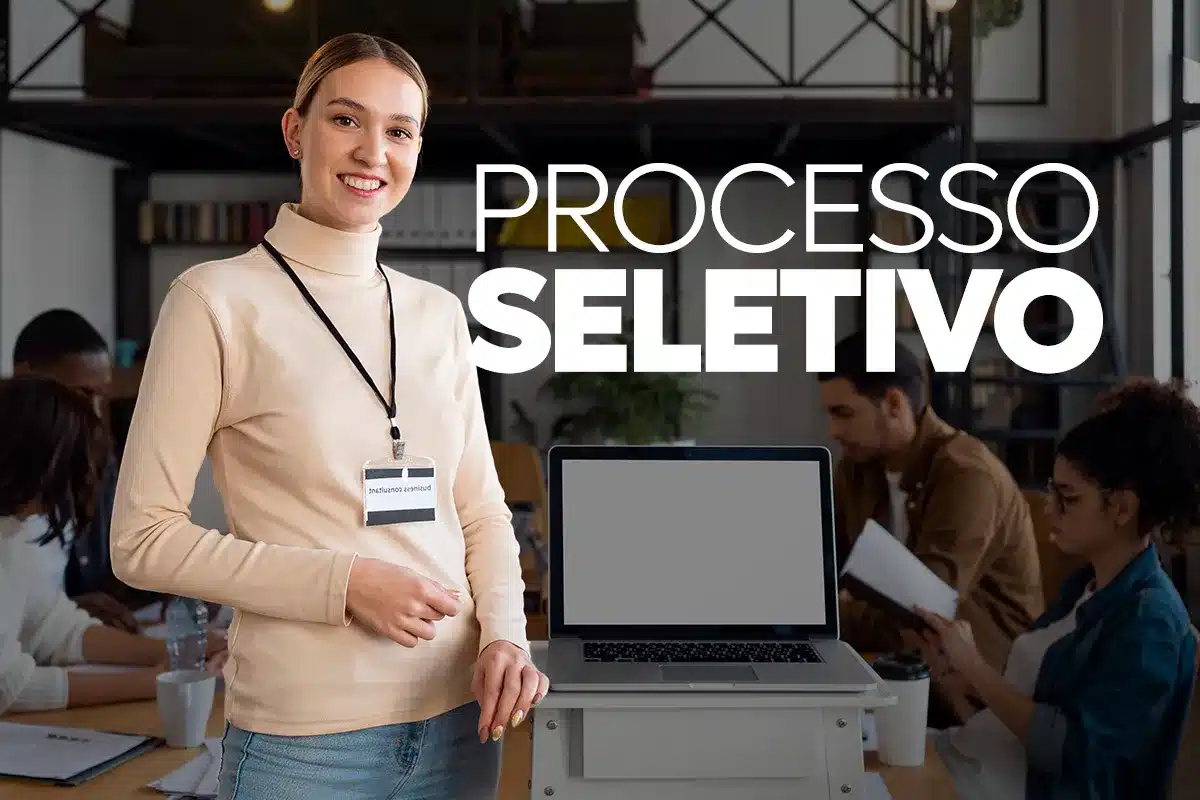 Imagem de processo seletivo com profissional sorrindo e apresentando notebook, representando as vagas públicas na Prefeitura de São João d'Aliança.