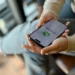 Pessoa segurando smartphone com WhatsApp aberto, ilustrando como evitar mensagens de listas de transmissão.