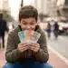 Adolescente sorrindo ao segurar dinheiro na mão em rua urbana, representando oportunidade de renda para jovens em projeto da prefeitura.