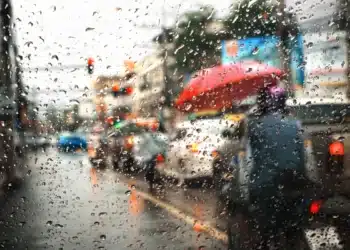Vista de trânsito com chuva intensa através de uma janela, representando o alerta para a região Norte e Extremo Sul neste fim de semana