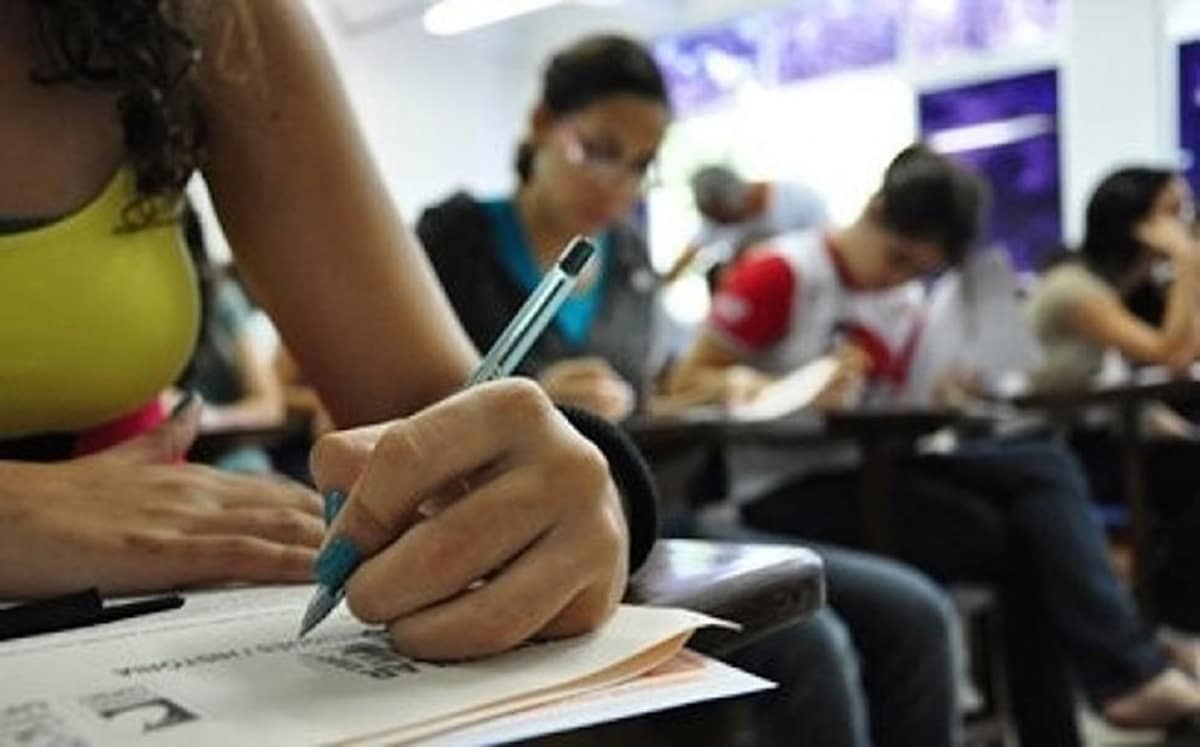 Provas concurso TCE RN 2026 - candidatos realizando prova em sala de aula com canetas e folhas de resposta