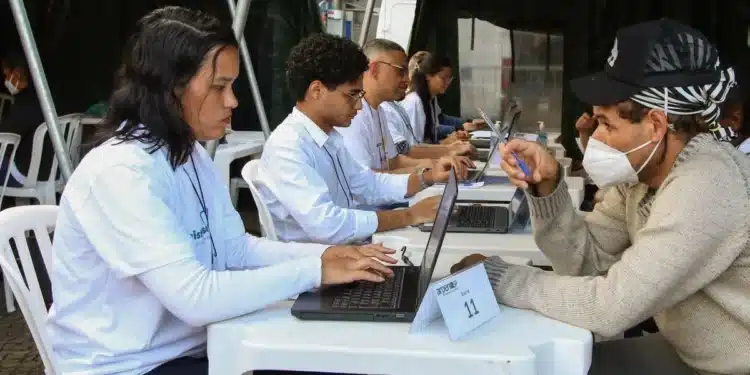 Profissional atendendo cidadão para emissão de documentos, representando o serviço prestado durante o mutirão de registro civil.