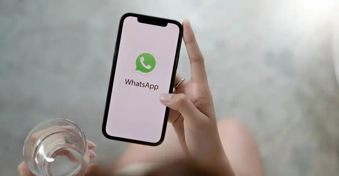 Pessoa segurando celular com WhatsApp aberto, representando configuração de proteção de IP nas chamadas