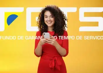 Mulher sorrindo com celular na mão — saque do FGTS em abril de 2026