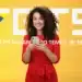 Mulher sorrindo com celular na mão — saque do FGTS em abril de 2026
