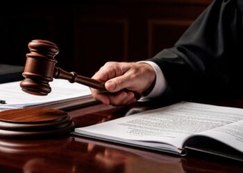 Juiz segurando o martelo em uma sala de tribunal, simbolizando a tomada de decisões e a autoridade judicial.