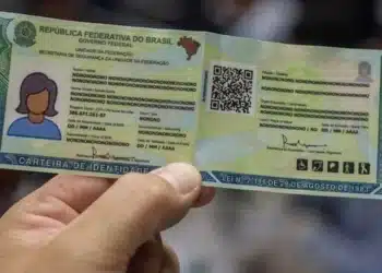 Carteira de identidade brasileira sendo segurada, representando a exigência de biometria para benefícios do INSS a partir de 2027.