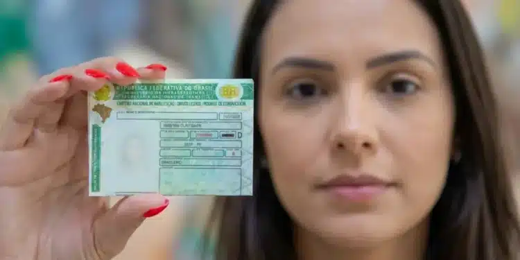 Mulher segurando sua carteira de motorista brasileira, destacando o documento em primeiro plano.