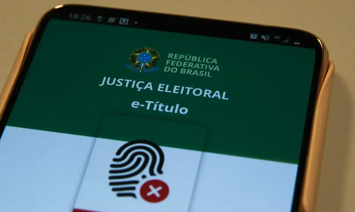 Aplicativo e-Título exibido em smartphone representando o prazo e o processo de solicitação e regularização do título de eleitor
