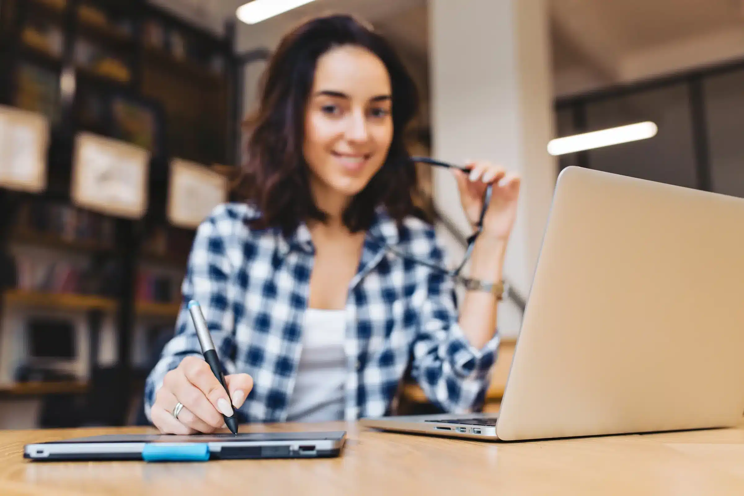 Mulher realizando inscrição online em concurso público da Câmara de São Paulo usando notebook.