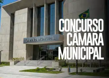 Fachada de prédio de Câmara Municipal com texto sobre concurso público e bandeira do Brasil hasteada