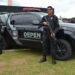 Dois policiais penais fardados e armados posam ao lado de viatura oficial do DEPEN Paraná